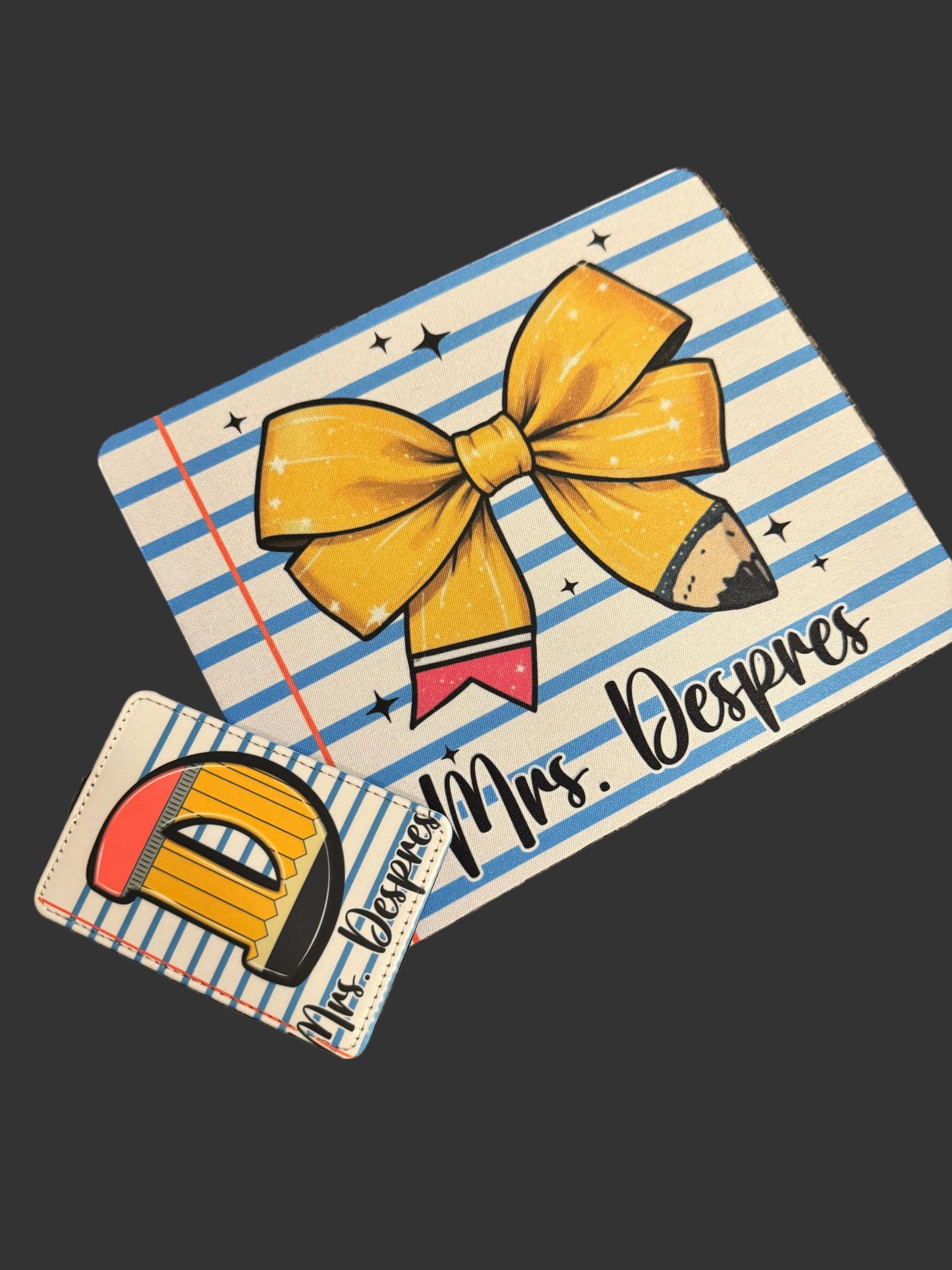 Two decorative items with a yellow bow and pencil design on a striped background.